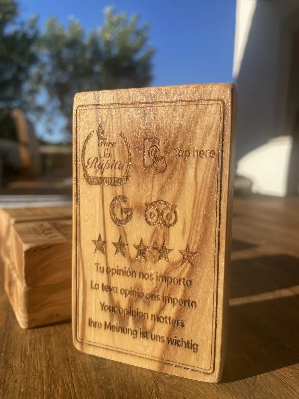 Placa de ullastre grabada con logo, iconos de Google y Tripadvisor y estrellas